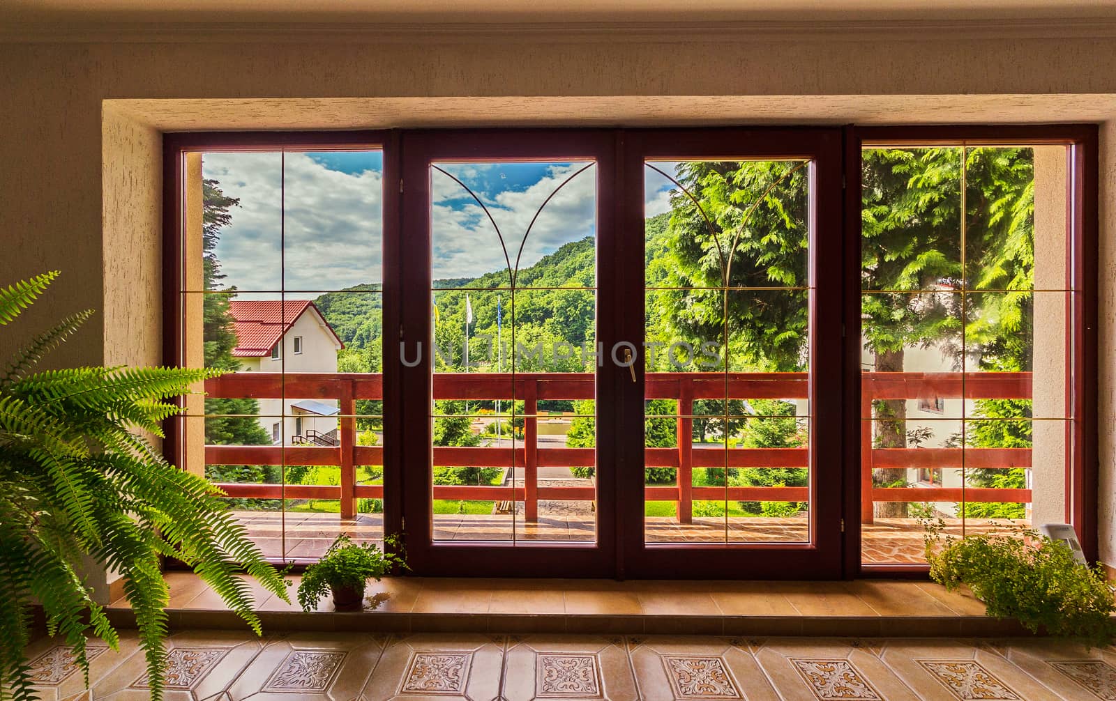 large glass doors in the house over which a panorama of mountains under the blue sky opens