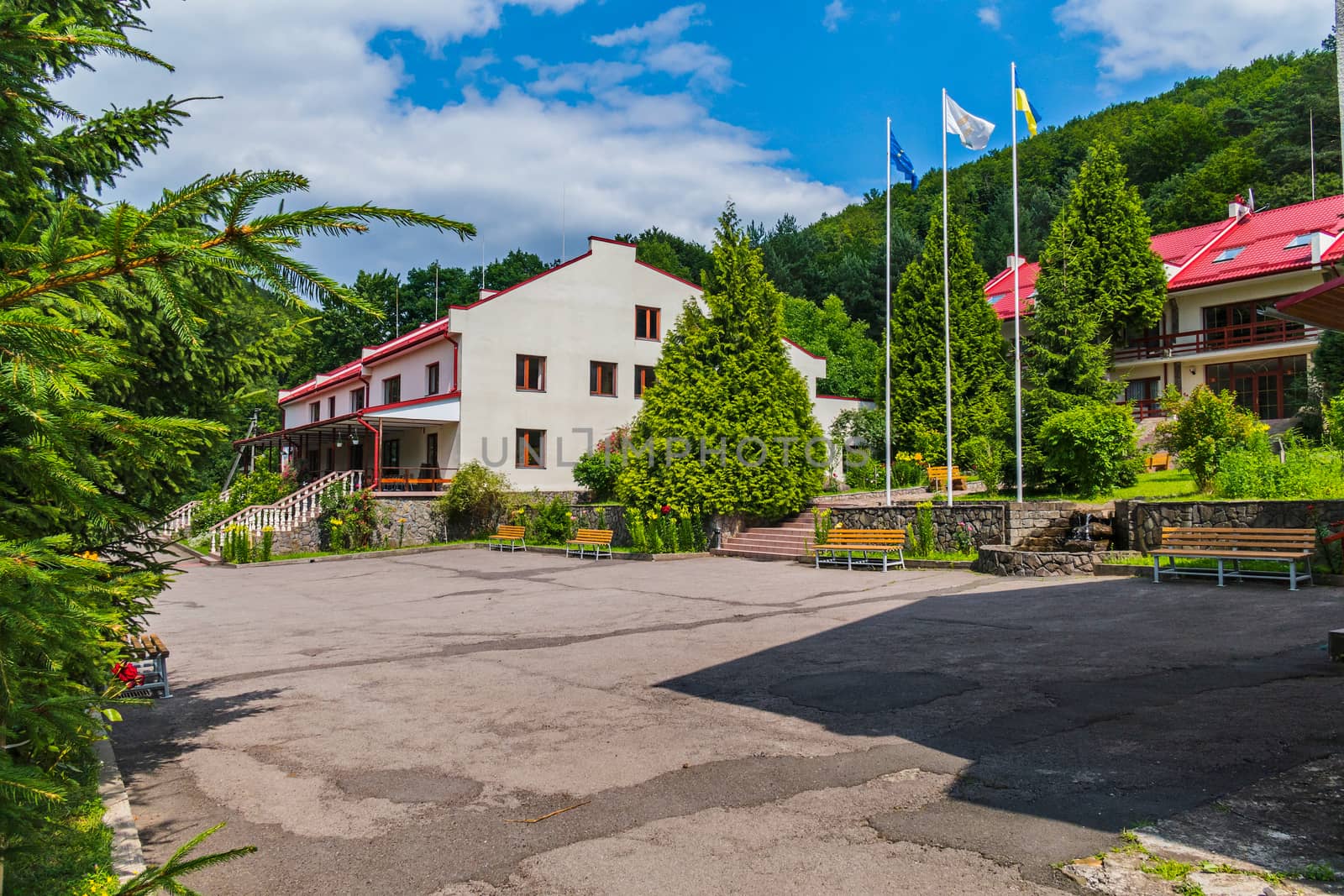 Comfortable wooden benches near the buildings of the hotel complex