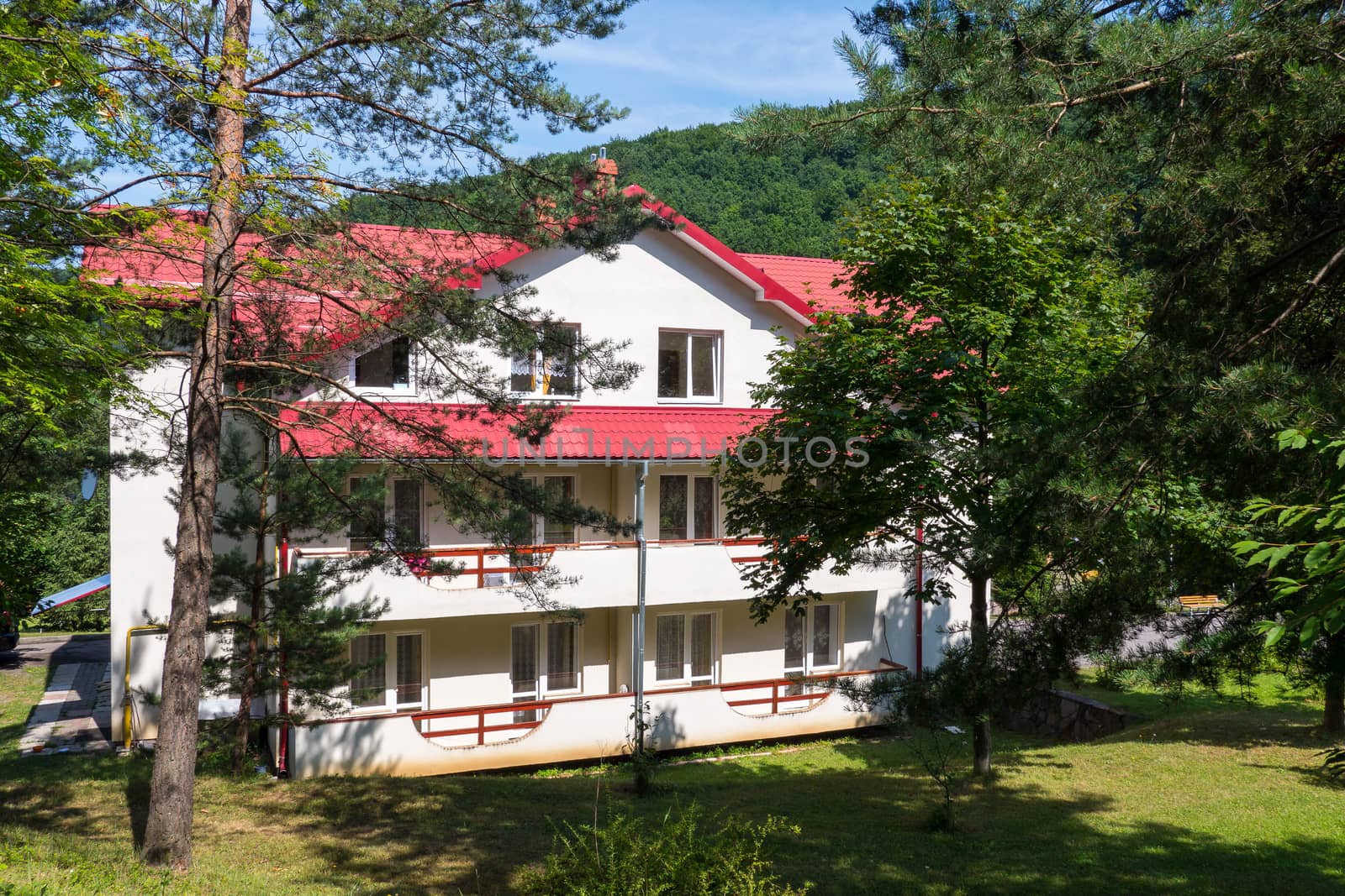 Cozy three-storey holiday house with wide balconies, white walls and a red roof