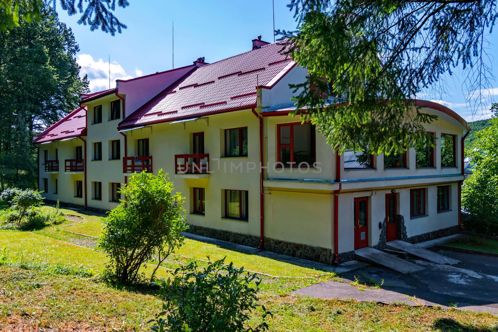 Two-story hotel complex with balconies and a red roof near the park zone