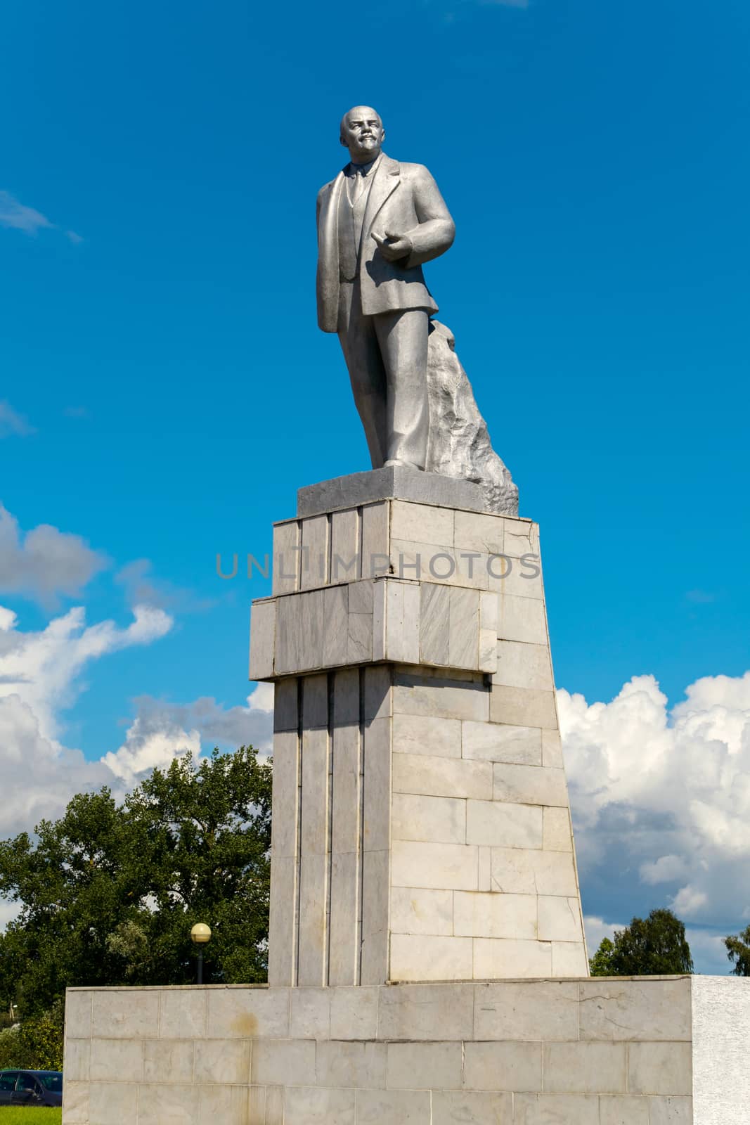 The monument of the historical person V.I. Lenin standing on a high pedestal against the blue sky. One of the most common monuments on the teritory of the former USSR.