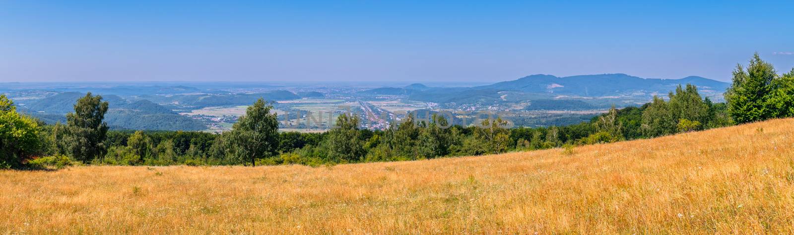 delightful panorama from the yellow slope to the city lying in a mountain valley by Adamchuk