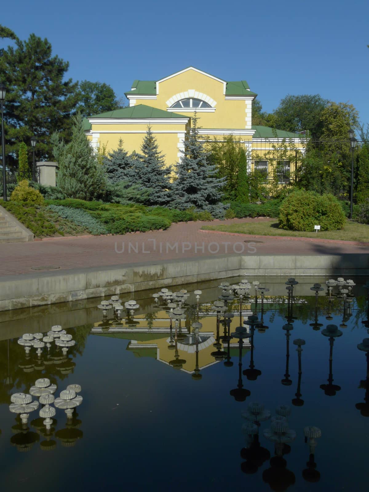 The building is yellow, reflected in a transparent blue lake, ag by Adamchuk