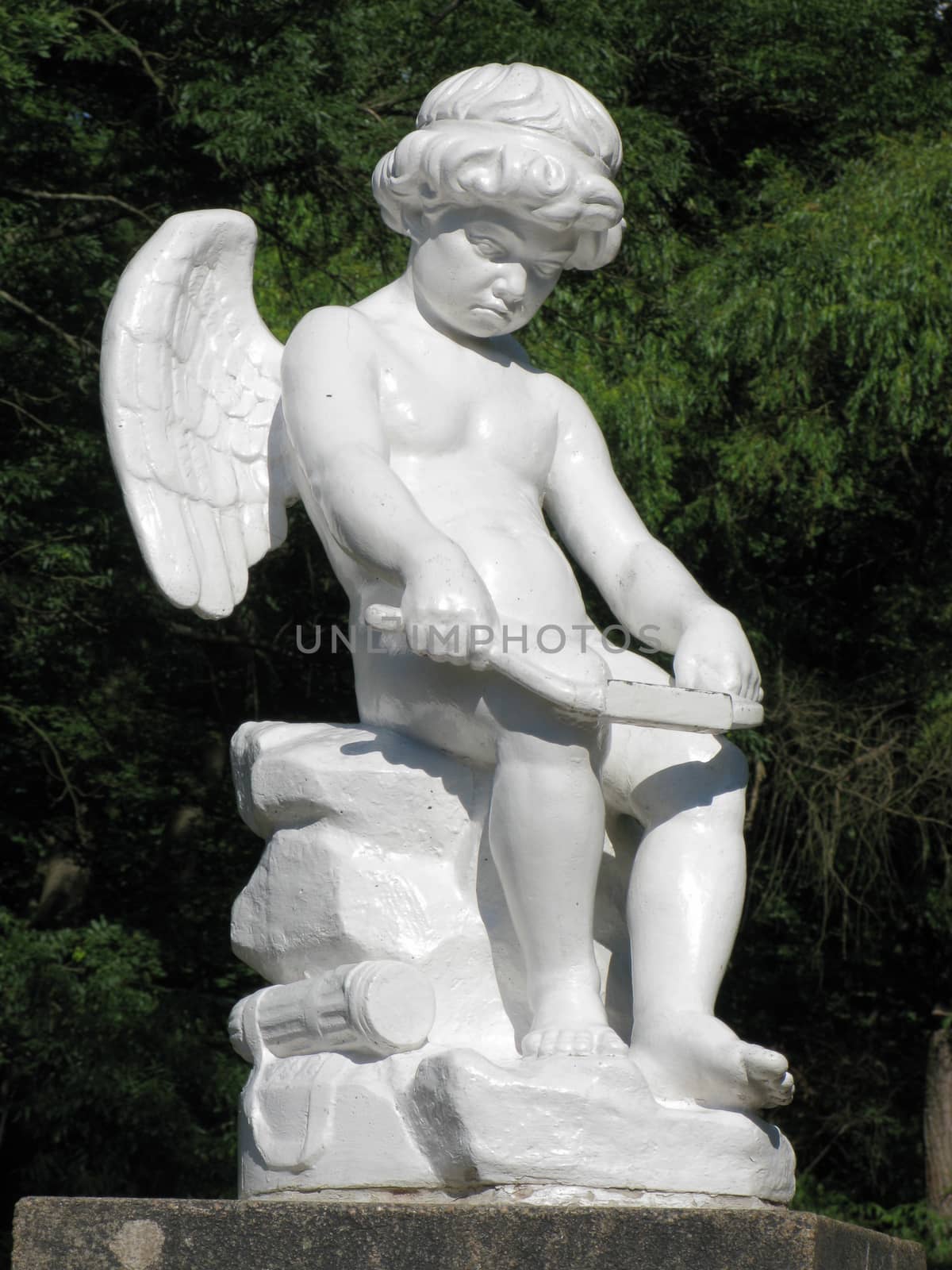 White statue of an angel with small wings, busy with work by Adamchuk