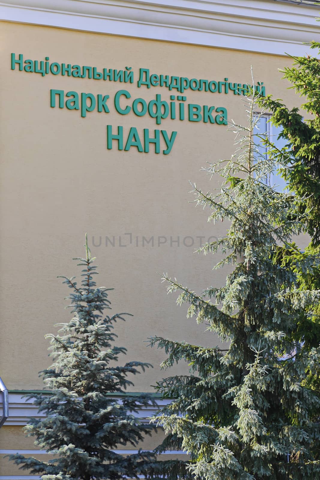 Building of the National Dendrological Park Sofivka in the shade of green tree branches