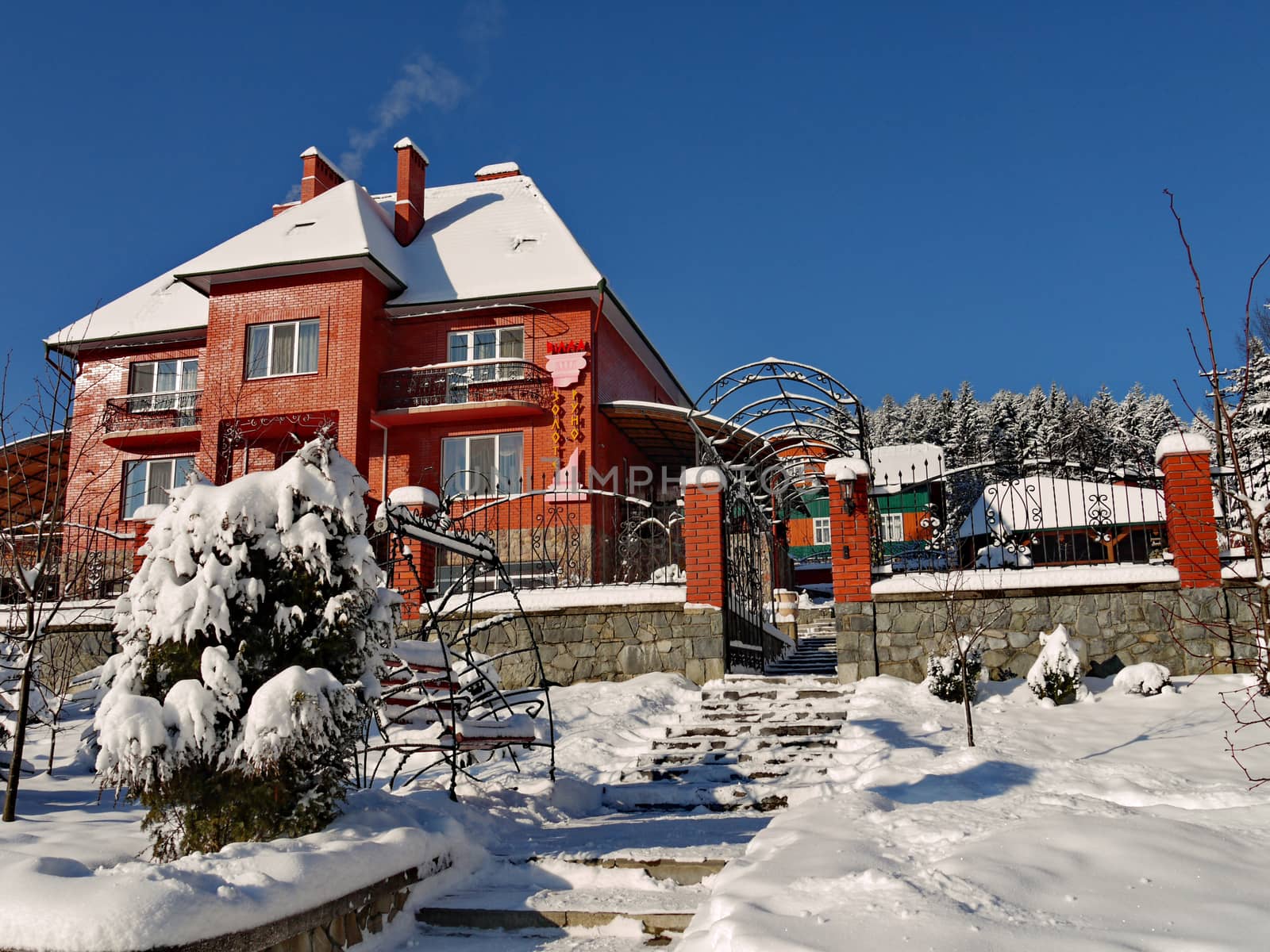 Beautiful two-storeyed villa from a red brick strewn with white snow