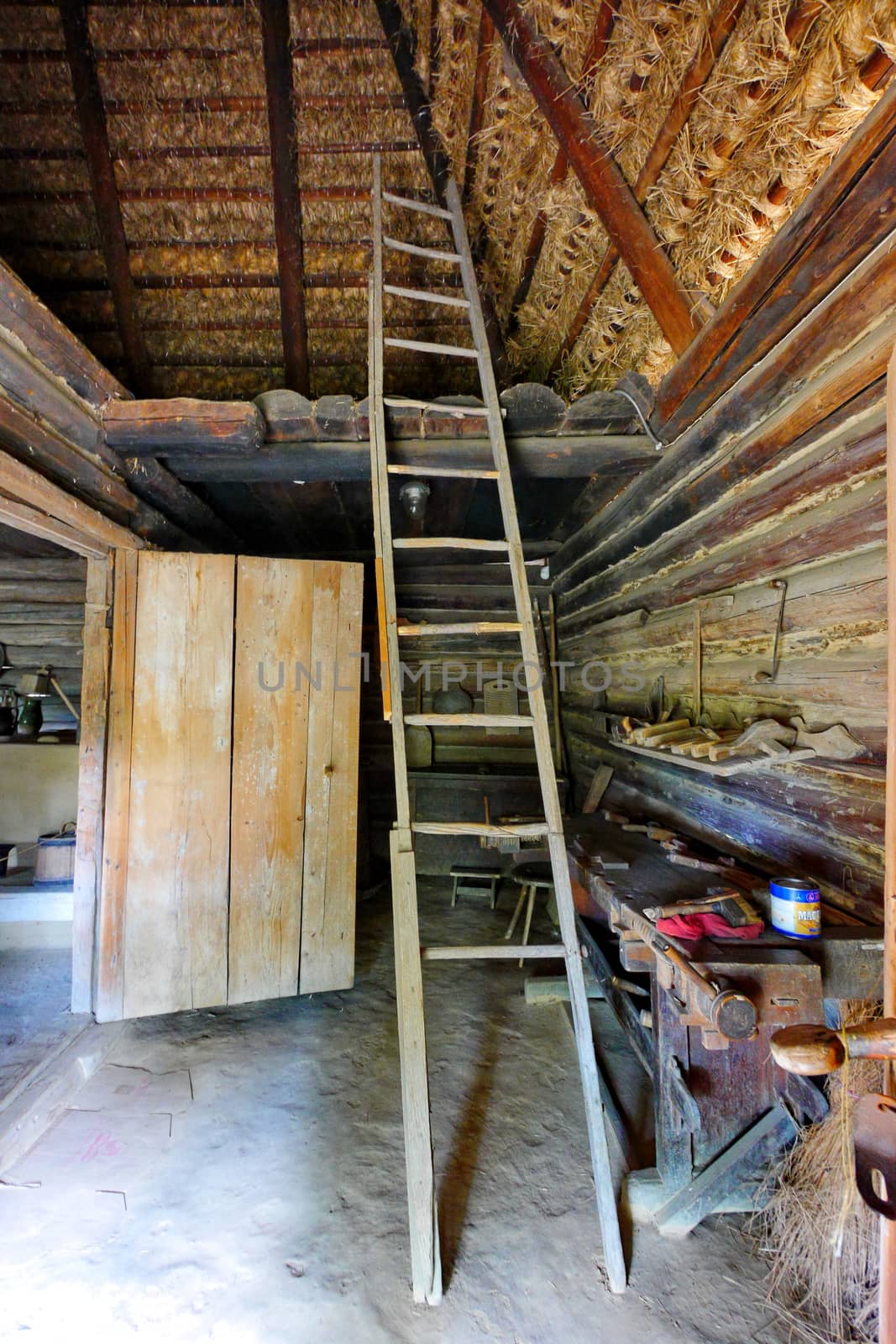 High wooden staircase leading to the attic of a traditional Ukrainian hut by Adamchuk