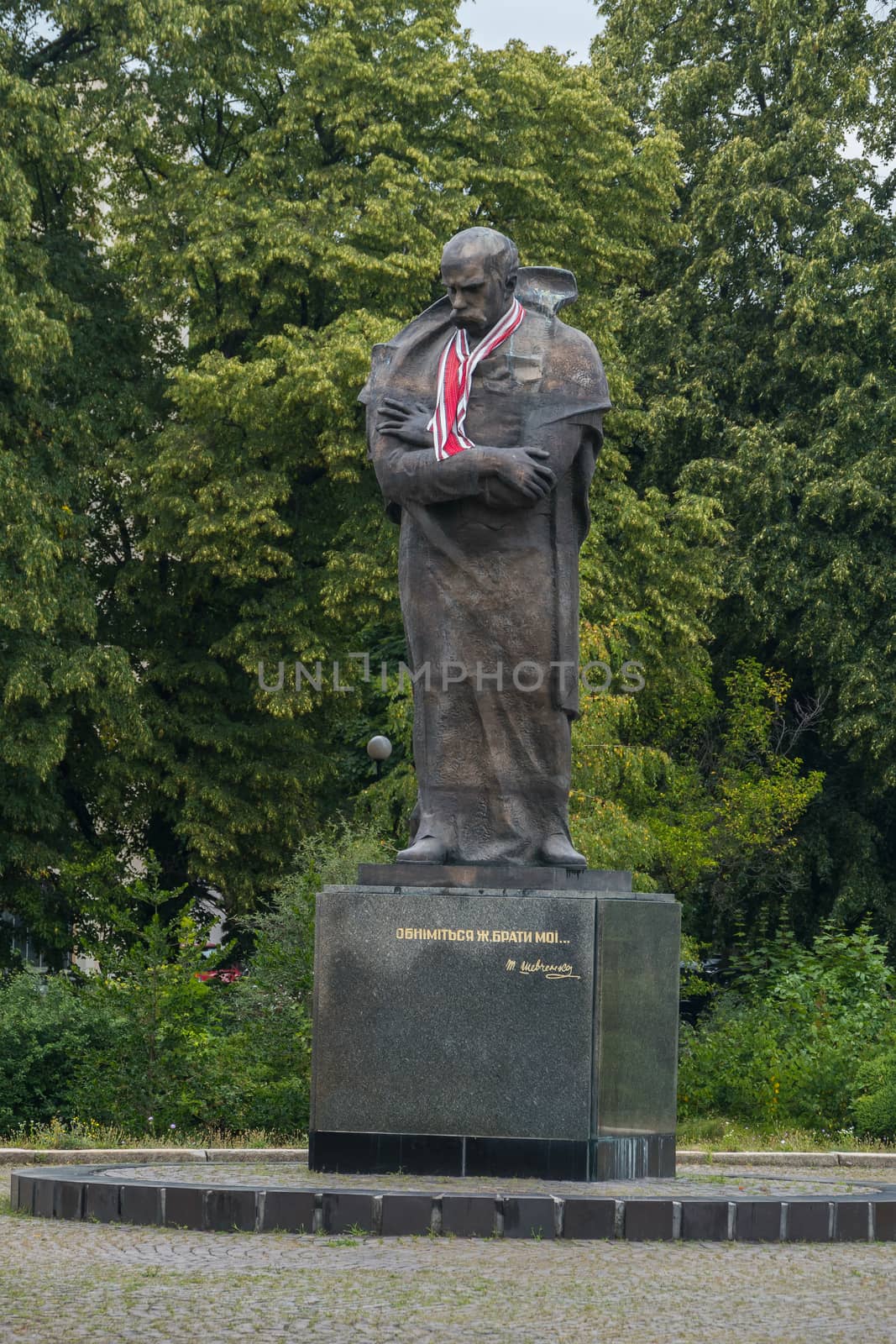 a thoughtful monument to Taras Shevchenko, who bowed his head down against the greenery of trees by Adamchuk