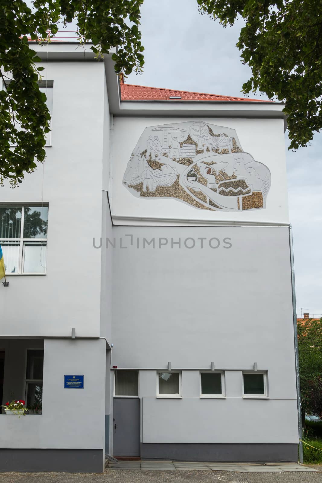 picture on the facade of a large white house in the city near the park by Adamchuk