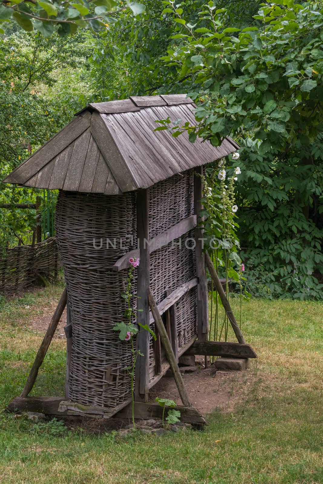 Decorative wooden well with a roof and curling flowers on the sides