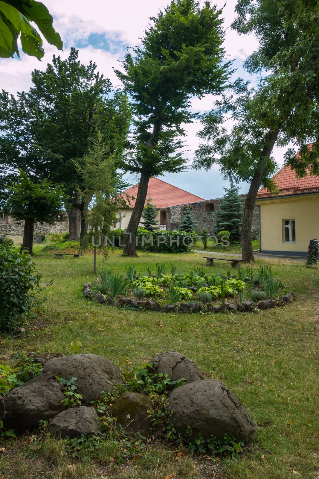 Park area with large decorative stones and flower beds in the background of beautiful trees