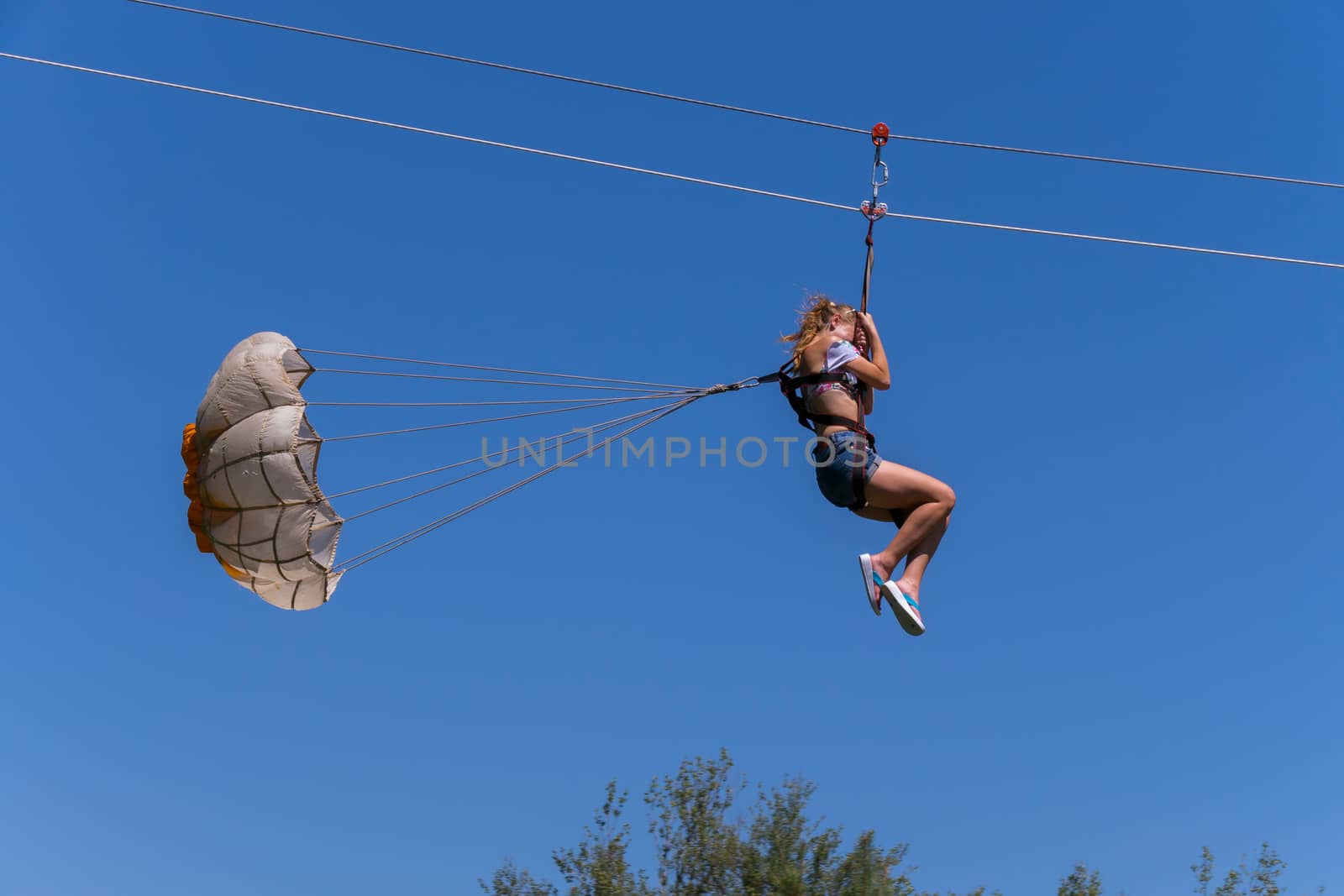 girl walking down the cable car with a parachute