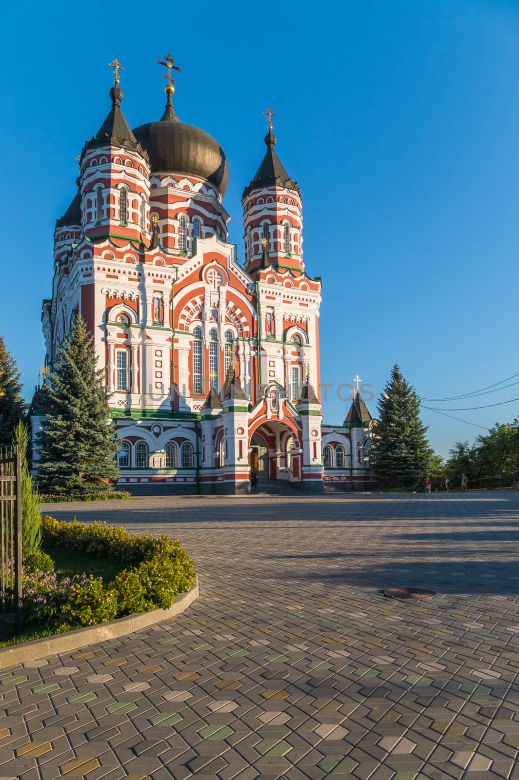Church with large domes on the background of a cloudless blue sky by Adamchuk