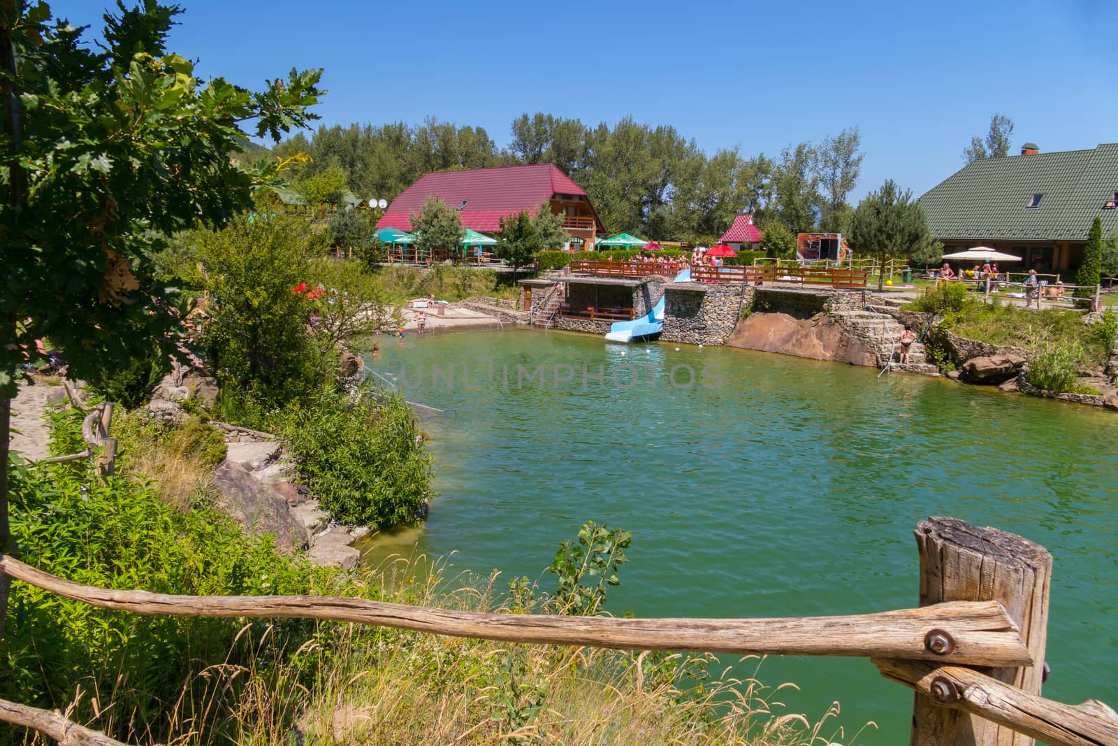 vacationers at tables tourists on the shore of a small pond located in a magnificent park