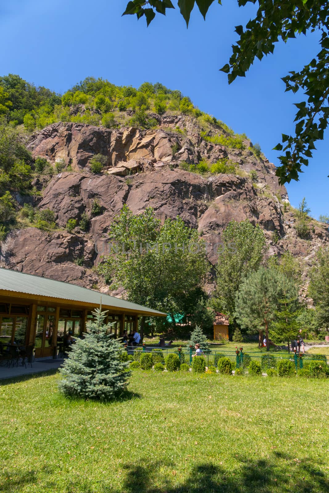 recreation area near the hotel at the foot of the mountain on the background of the blue sky by Adamchuk