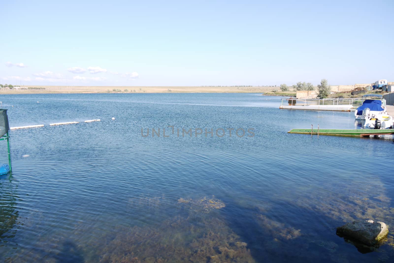 transparent clear water of a blue lake with piers along the shore