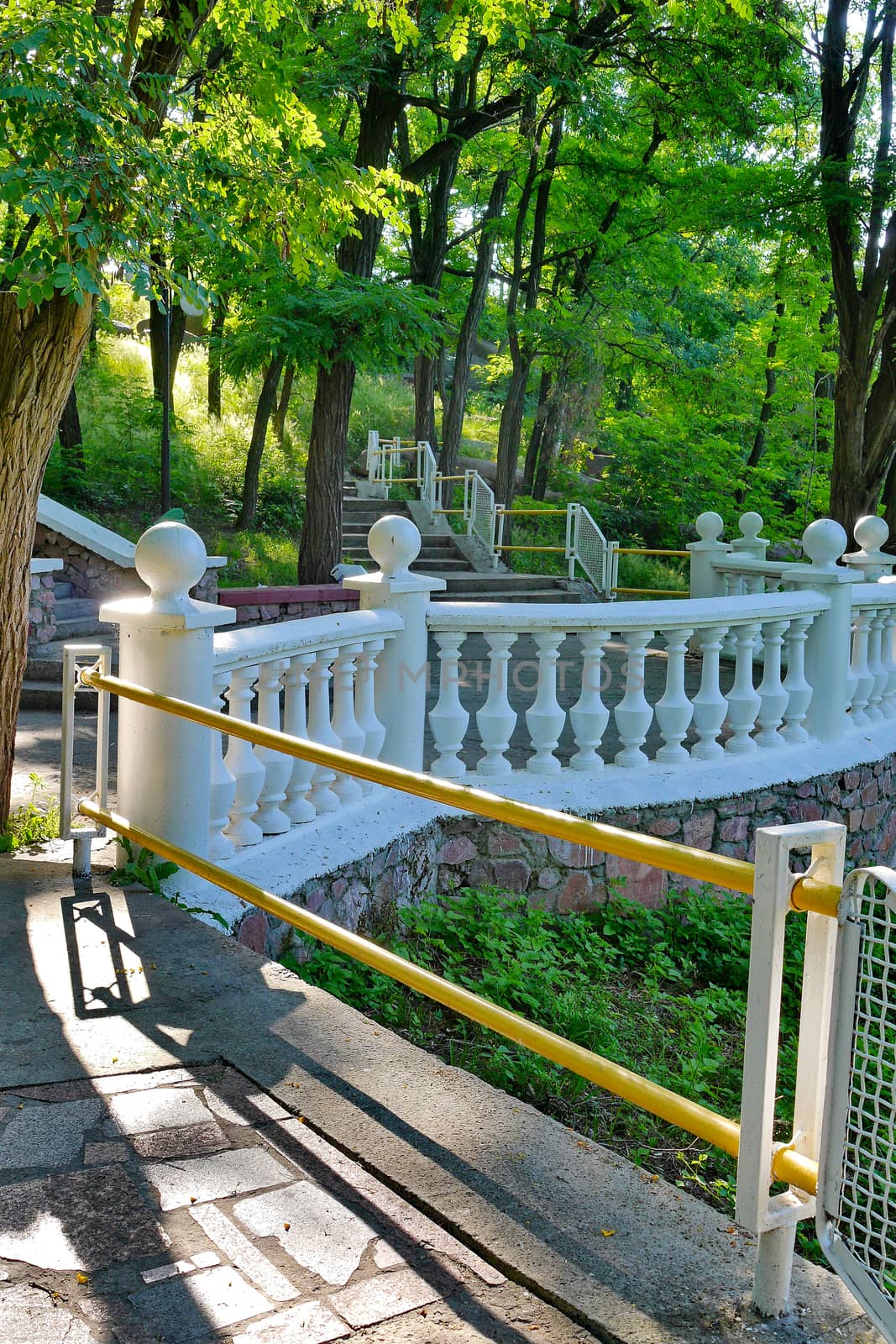 Tiled stairs with handrails leading to a large viewing platform with a white fence