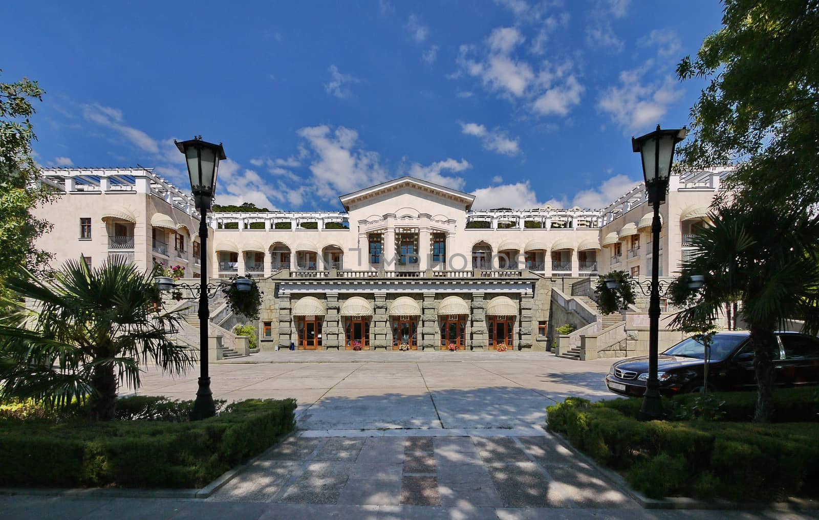 Magnificent view of the palace with beautiful architecture and white walls with stairs from both sides leading to the second floor standing in a park with picturesque nature.