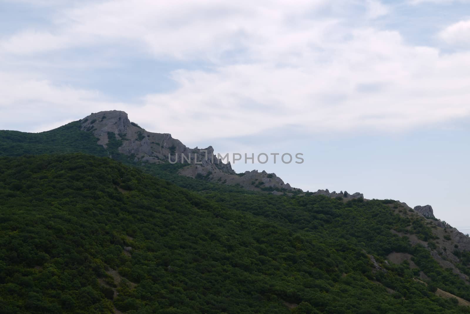 Cloudy with clearing on the rocky mountains covered with greenery