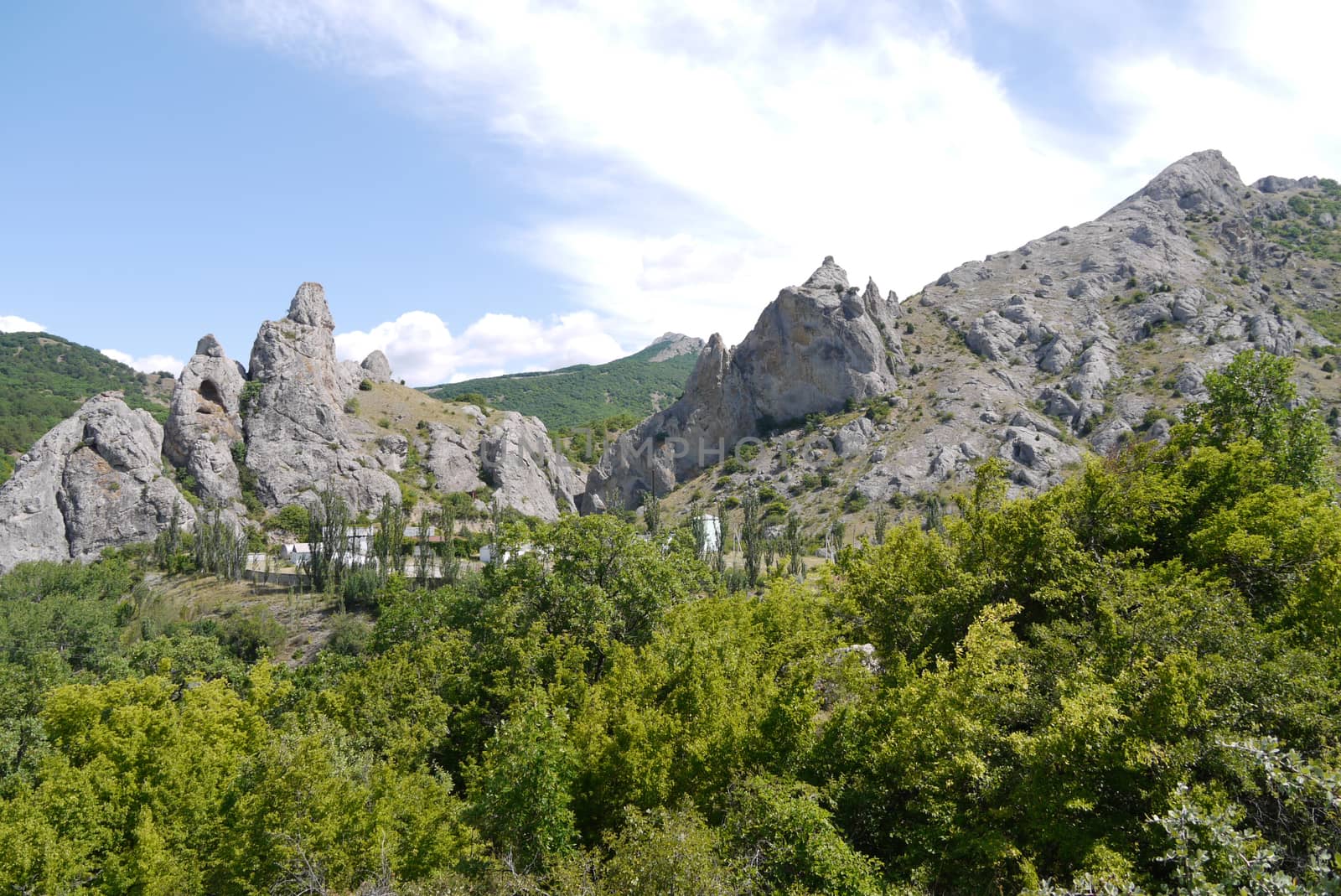 a landscape of spiny stone hills with a settlement in the valley between them