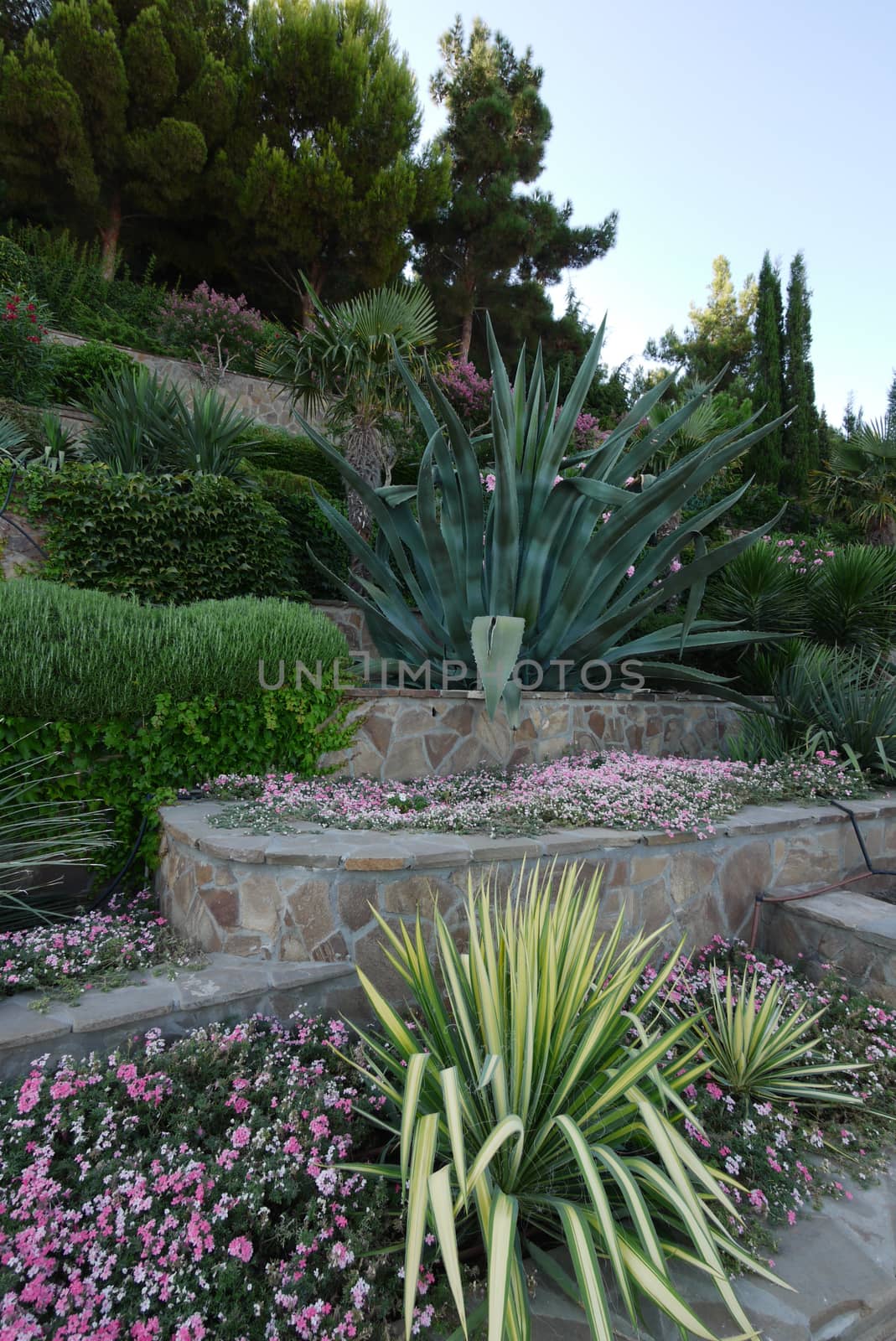 A multi-level flowerbed is covered with a mosaic of stones with various and colorful colors