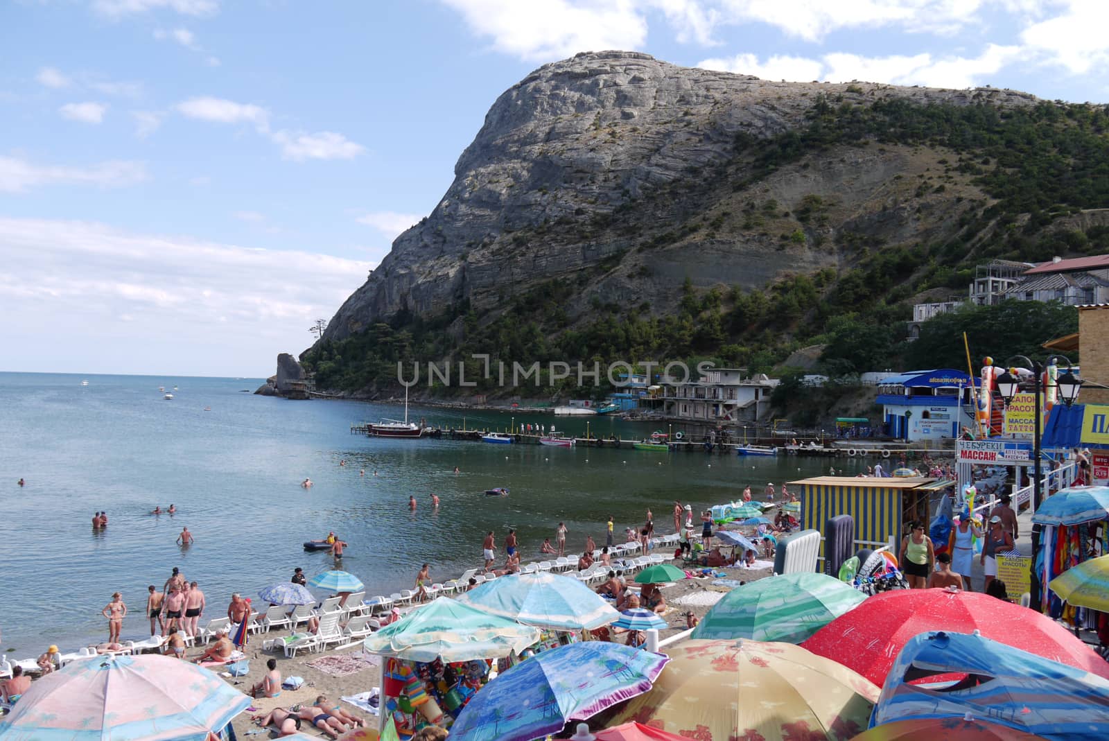 A sandy beach and a mountain creating a shadow over it and the sea. An ideal place for a curret