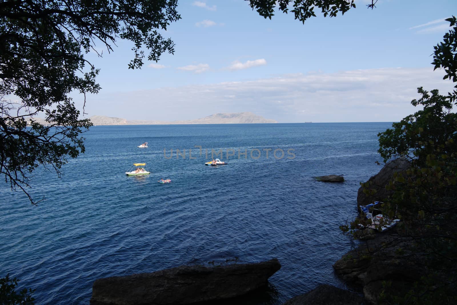 the water surface of the ocean with tourists strolling on boats by Adamchuk