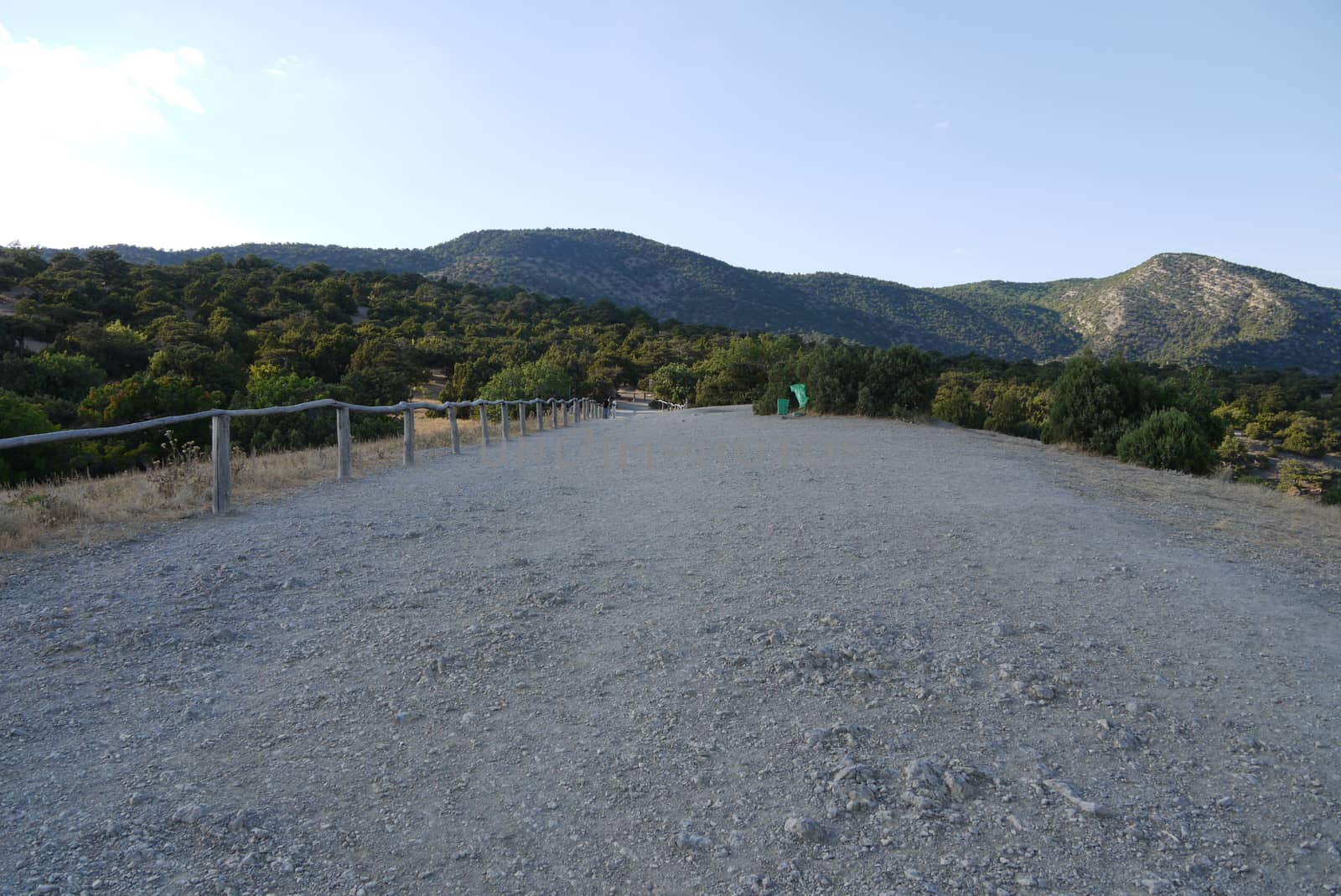 view of the Crimean mountains from a country road with a wooden fence by Adamchuk