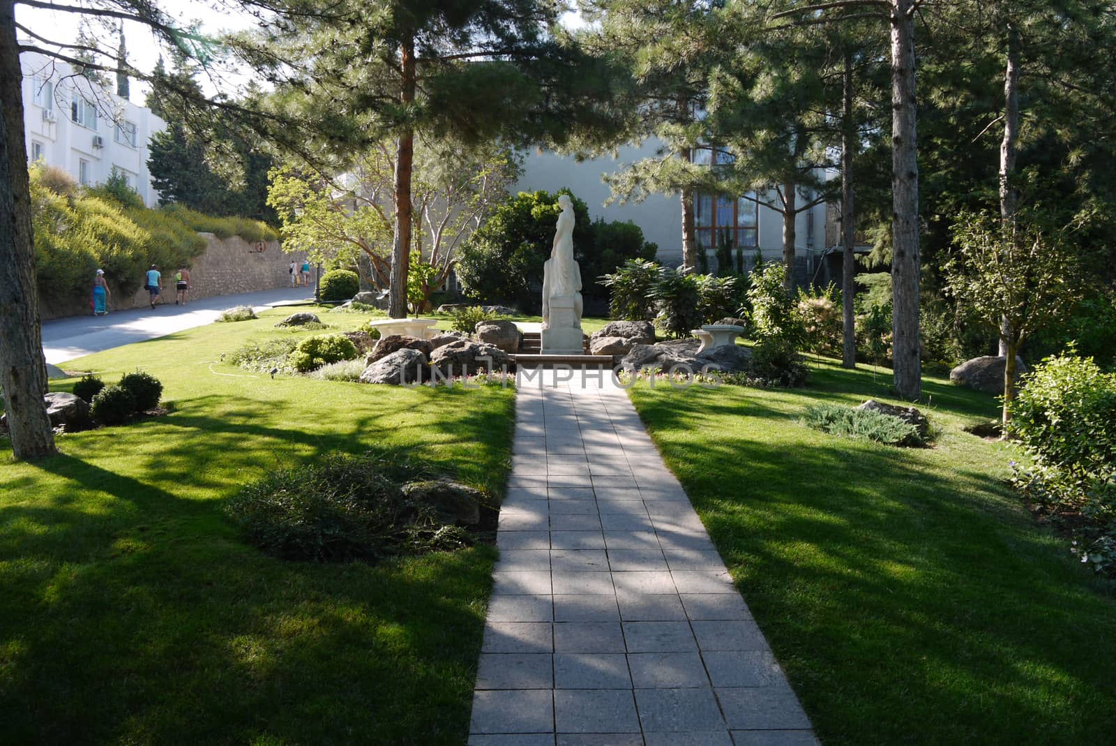 the path leading to a white statue surrounded by stones