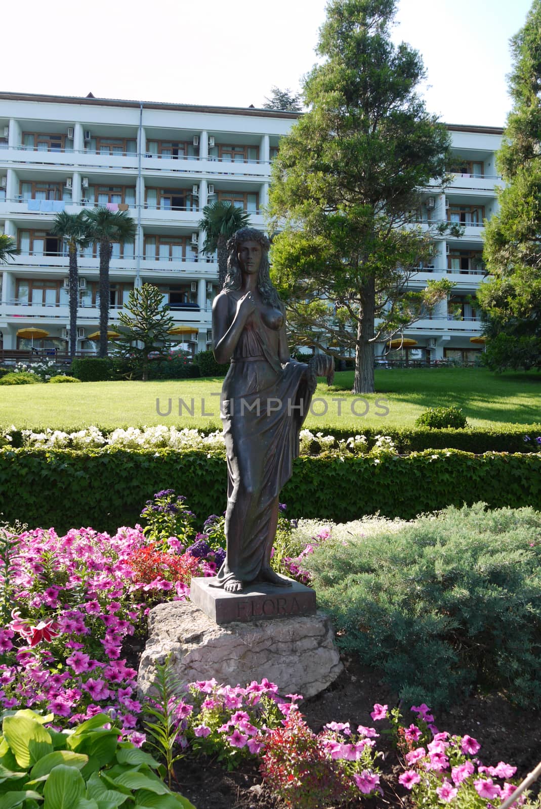 Sculpture of a woman on a green lawn standing on a stone with an by Adamchuk