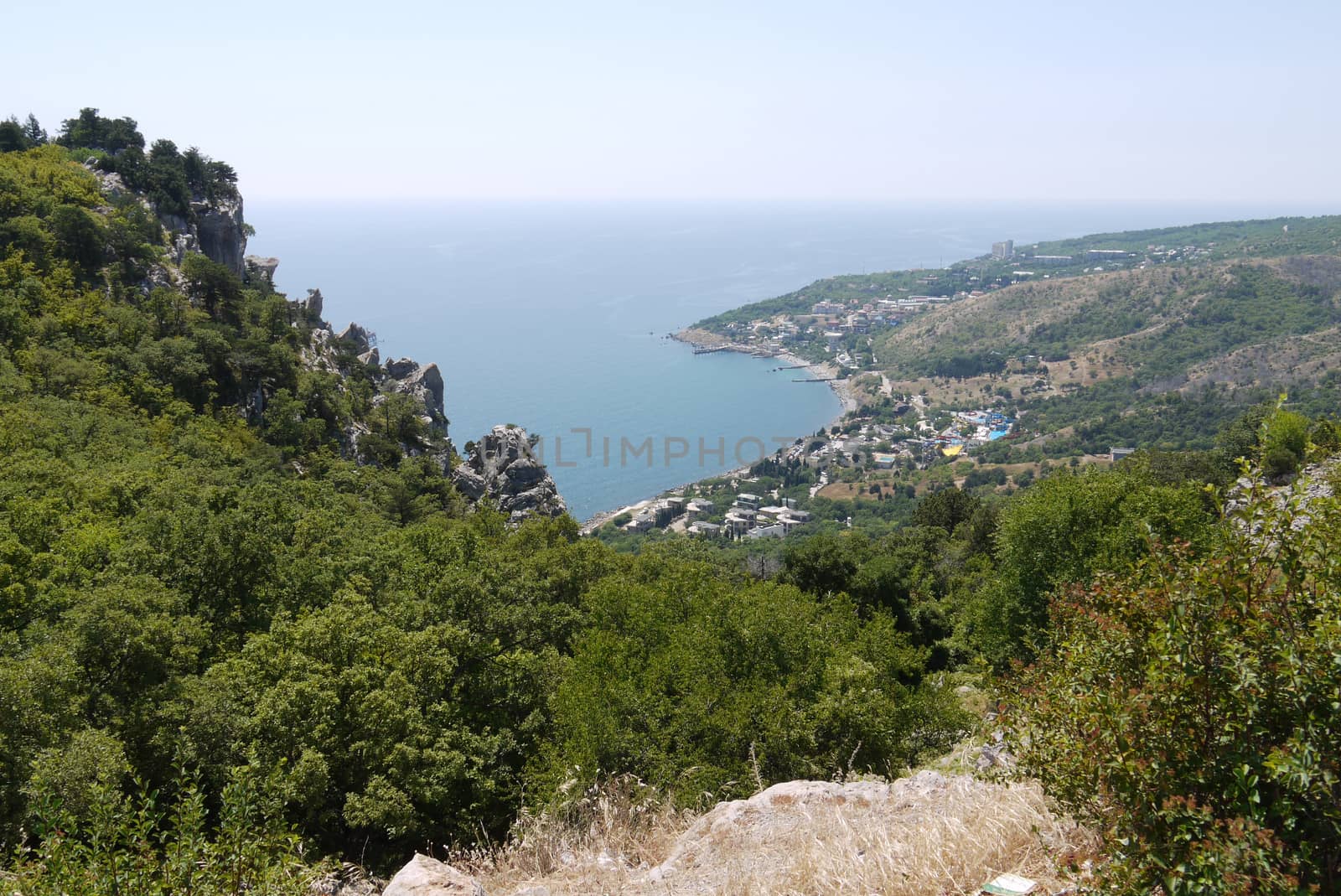 a small cozy town under a blue sky on the shores of a huge black sea by Adamchuk