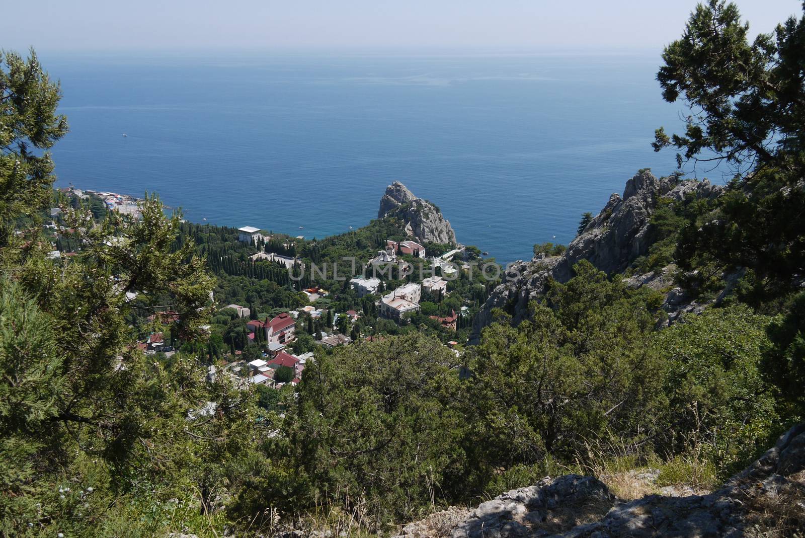 a quiet coastal town under a blue sky on the background of the boundless sea by Adamchuk