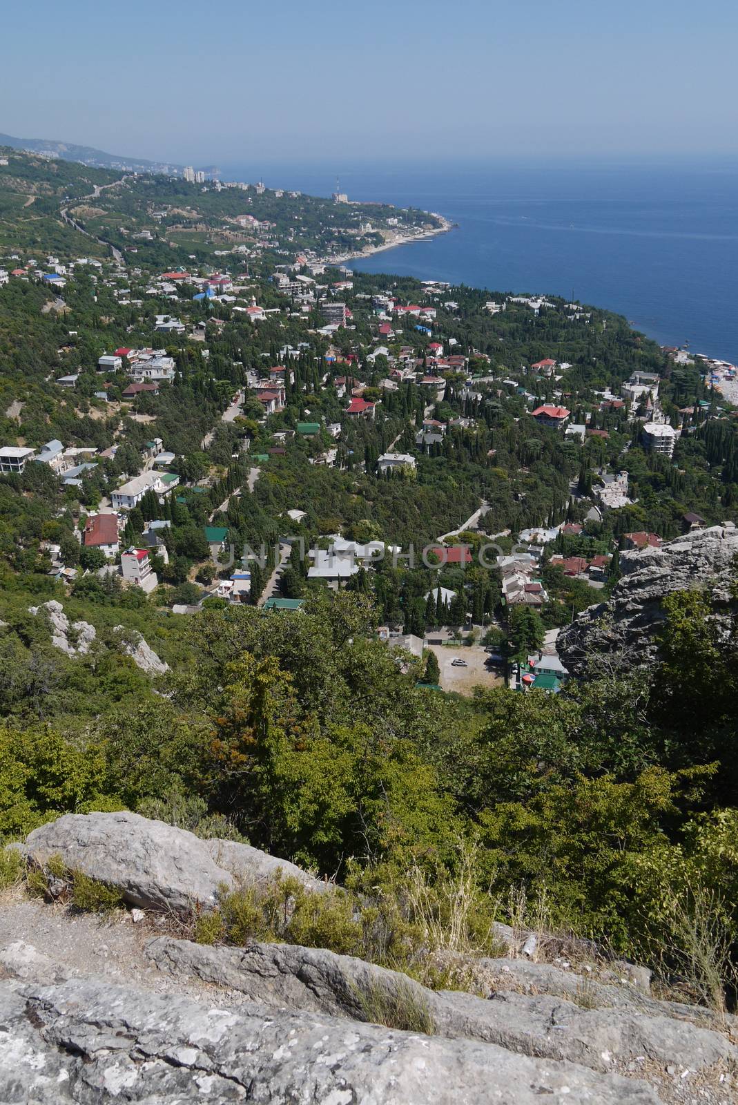 small grass-covered rocks on the background of a beautiful coastal town