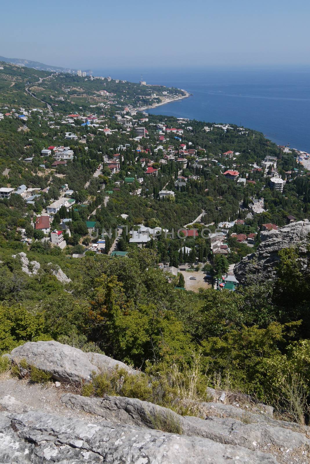 small grass-covered rocks on the background of a beautiful coastal town