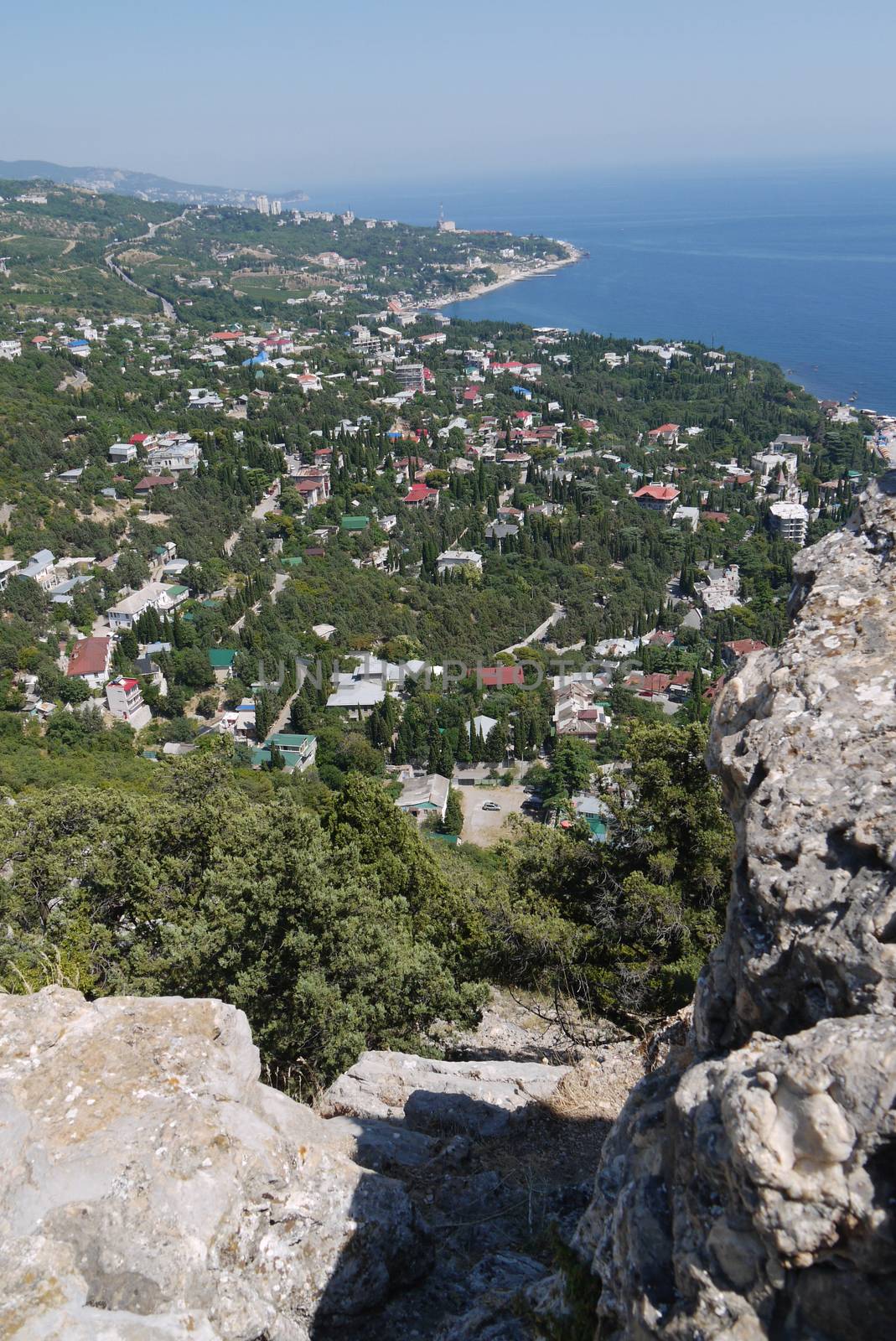 a small rock on the background of a beautiful quiet coastal town under a blue sky