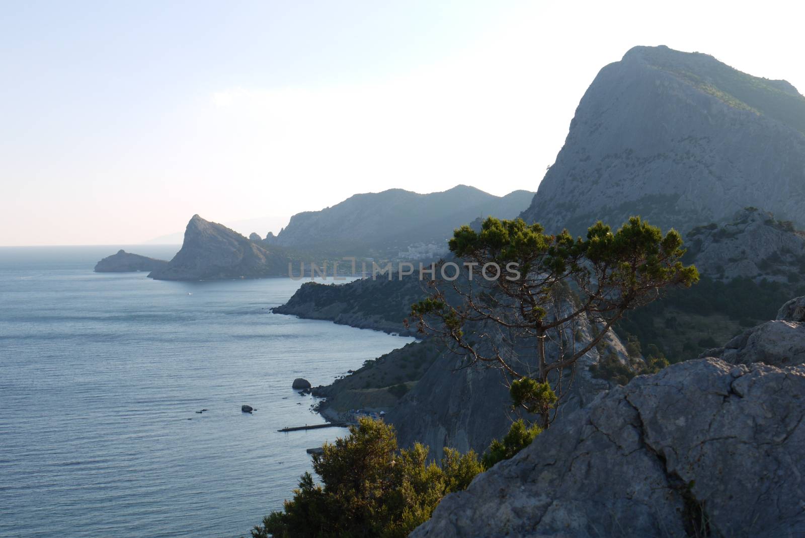 High, beautiful mountains on the shore of a deep black sea by Adamchuk