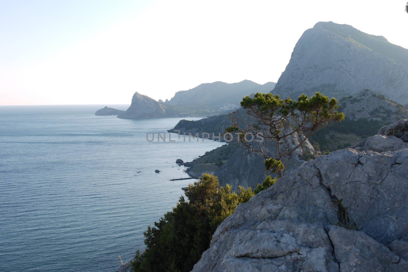 High cliffs under a blue sky on the shore of a wide, endless sea