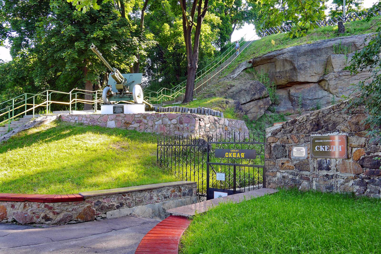 open-air museum on the background of a slope covered with grass and tall trees