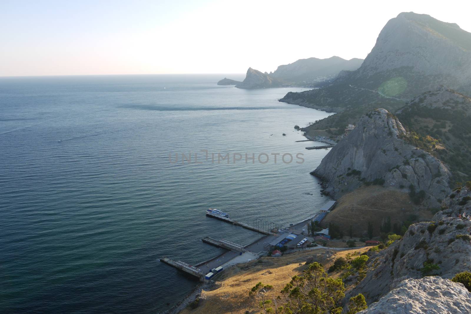 High, beautiful mountains on the shore of a deep black sea by Adamchuk