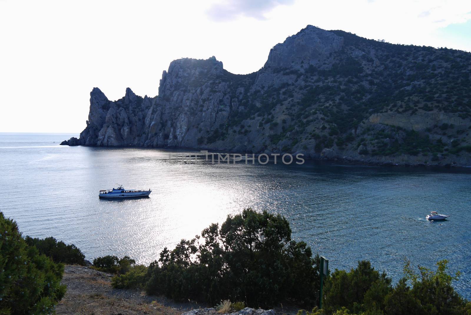 bay in the black sea on the background of steep cliffs covered with grass. Walking on a boat by Adamchuk