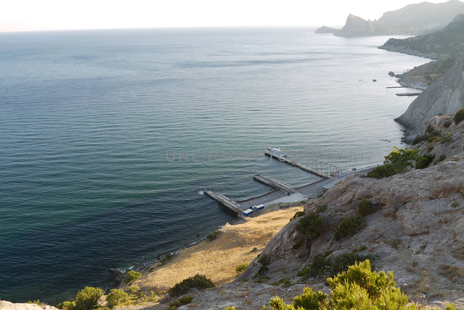 High, beautiful mountains on the shore of a deep black sea by Adamchuk