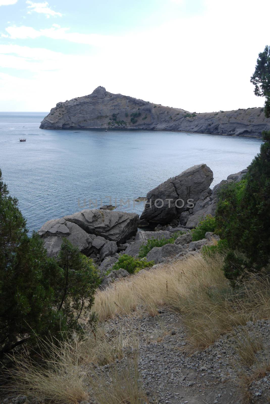 The wide bay is surrounded by high Crimean rocks covered with gr by Adamchuk