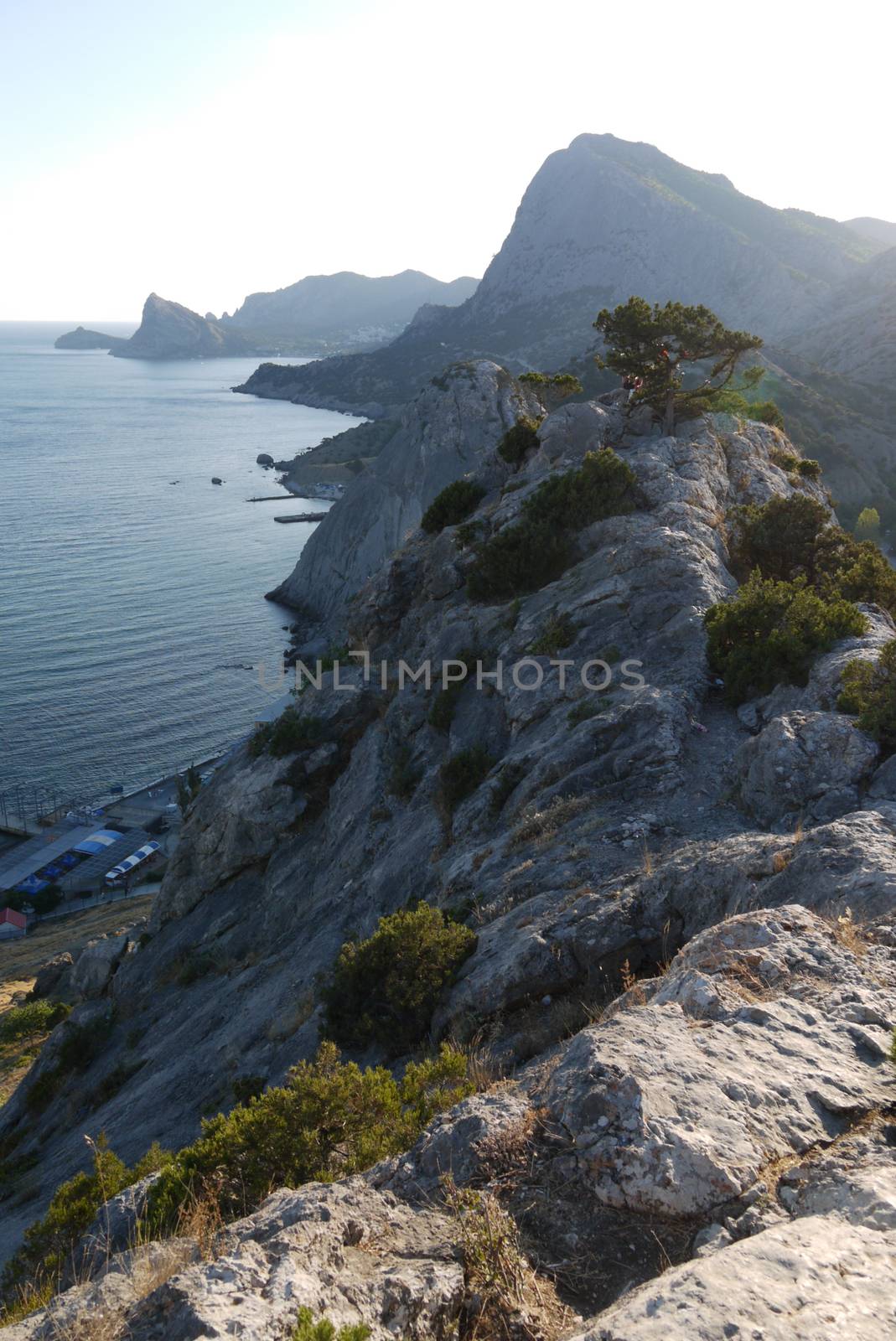 Coastal steep cliffs on the background of high mountains covered with grass