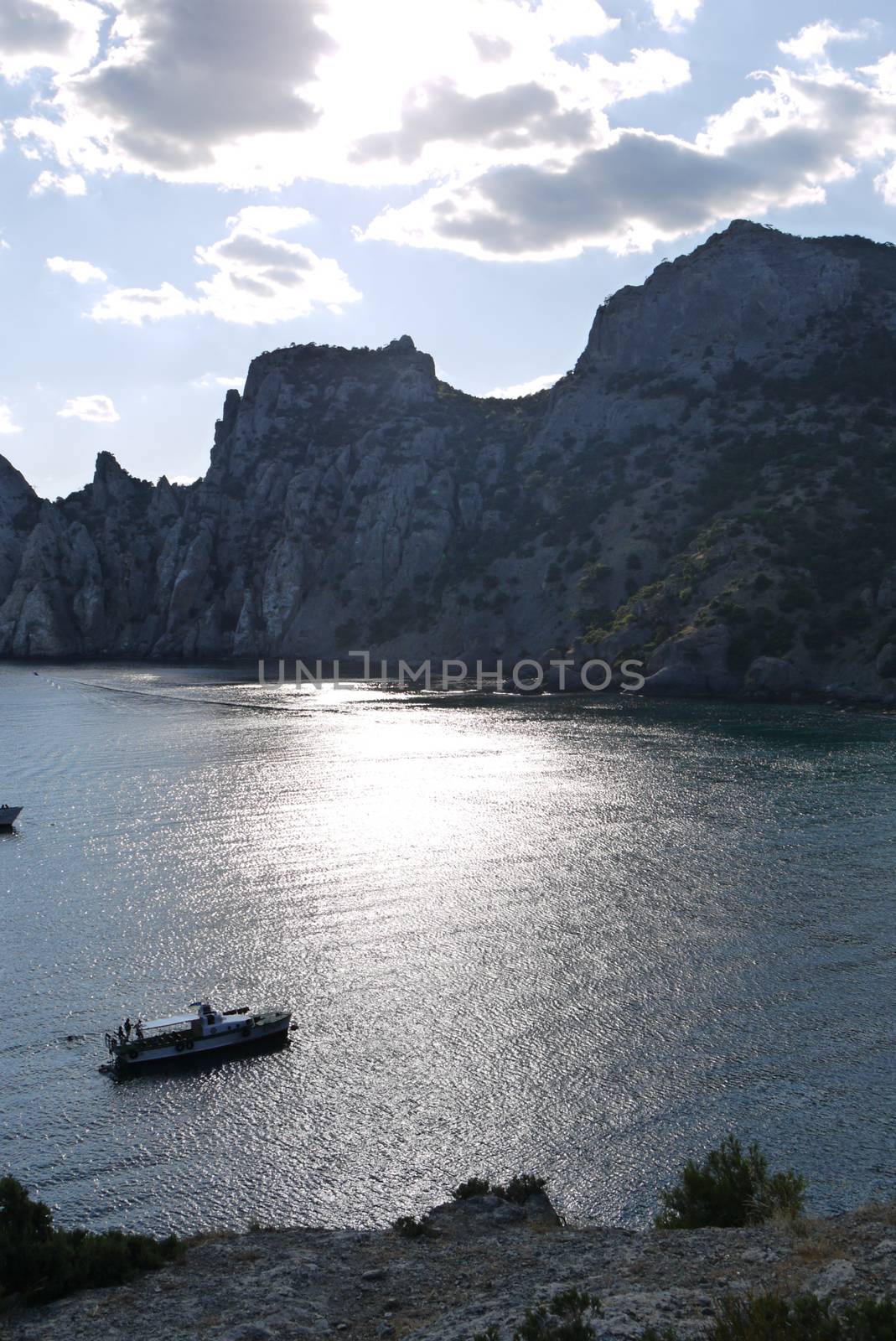 bay in the black sea on the background of steep cliffs covered with grass. Walking on a boat