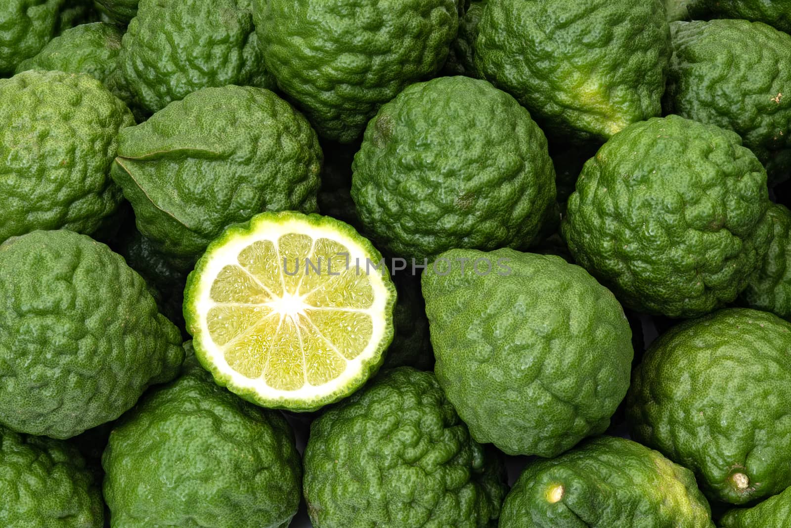 Kaffir limes, one cut citrus fruit for herbal medicine by praethip