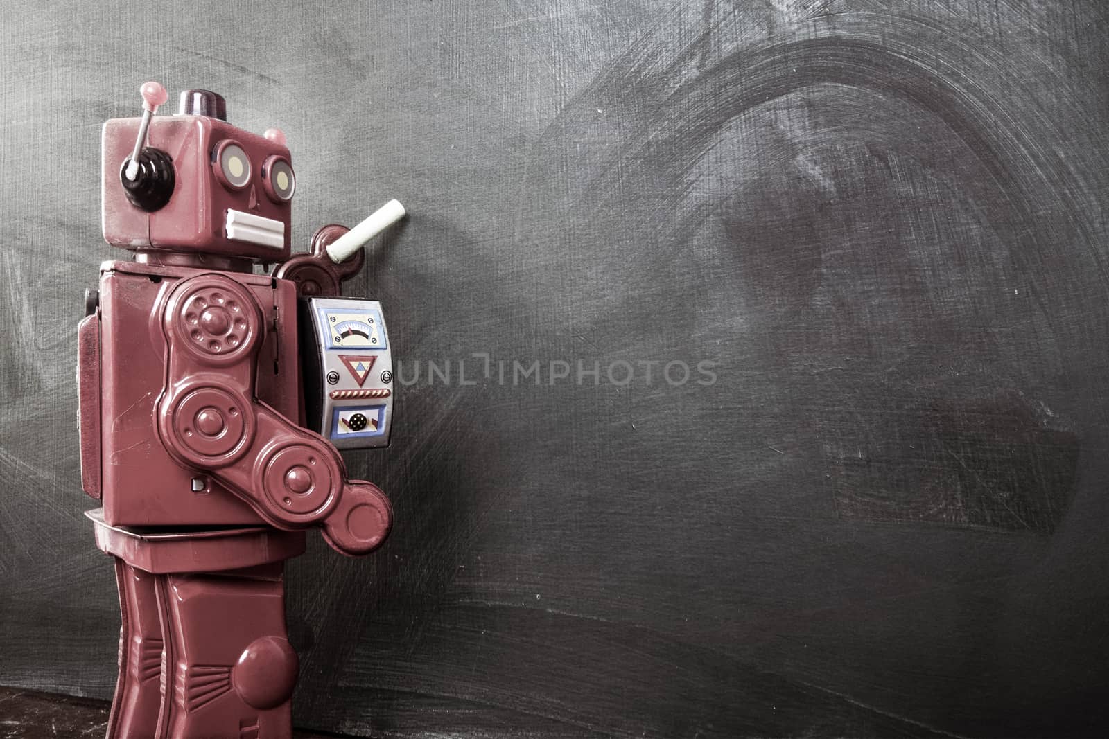 vintage robot writes on black board 