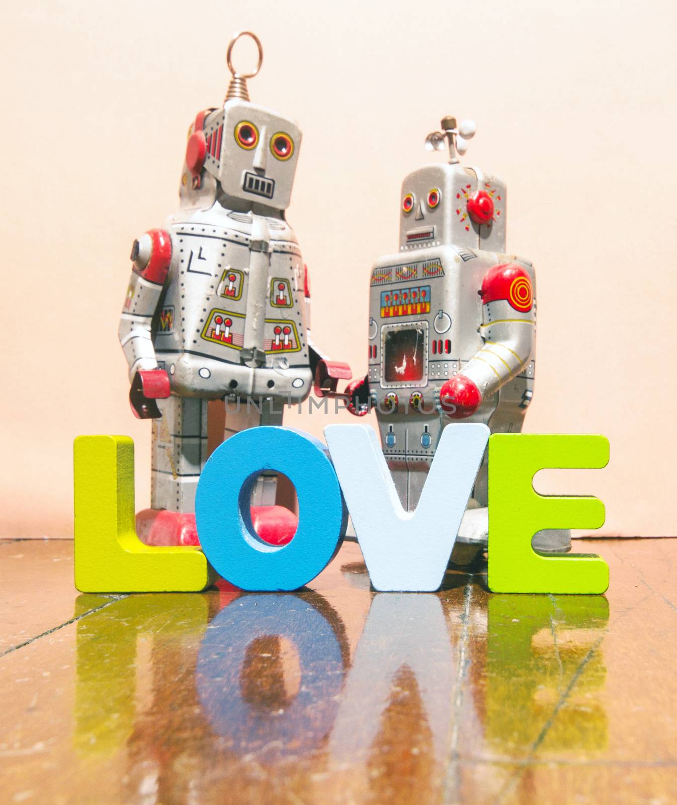 I LOVE U  with wooden letters on old wooden floor with two retro robot toys