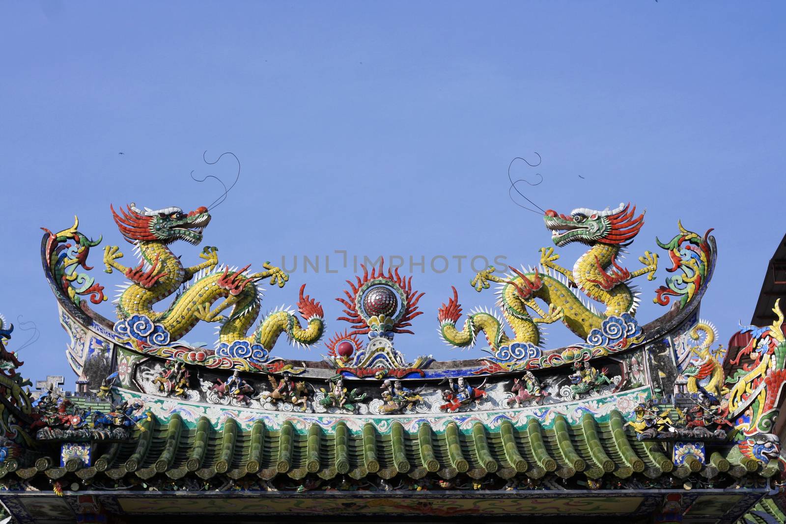 two Chinese Dragons on a roof with blue sky 