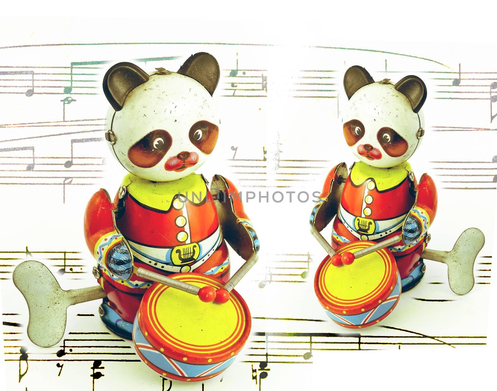 two retro tin pandas playing the drums 