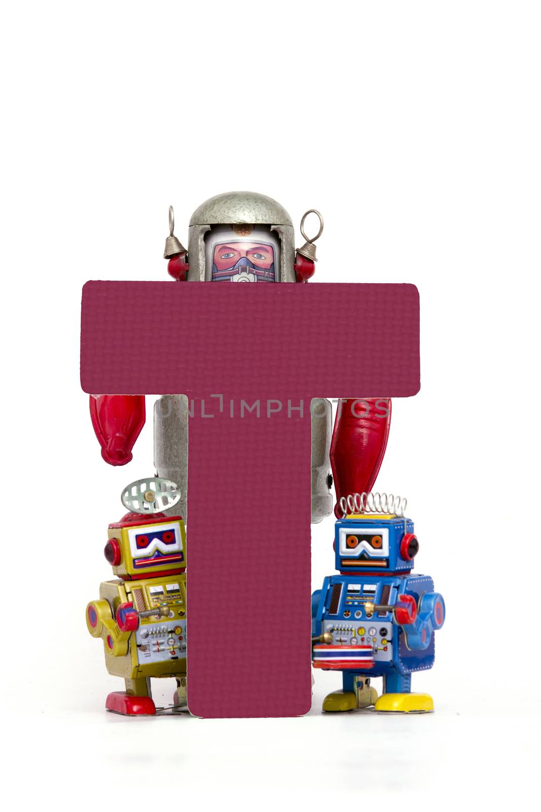 capital letter T held by vintage robot toys 